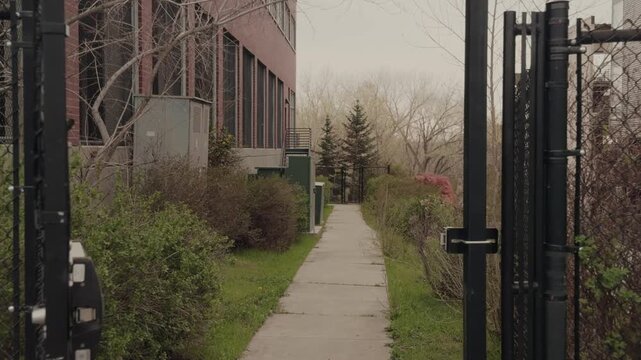 Smooth forward tracking shot entering narrow walkway between apartment complexes