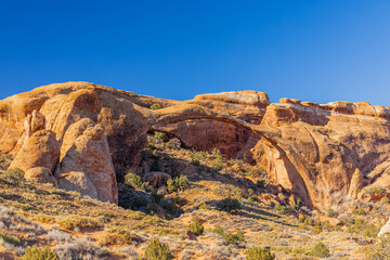 Naklejka premium The massive North Window arch spans rugged desert rock formations.