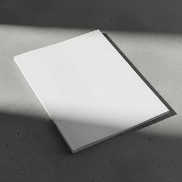 Blank white book cover mockup with dramatic shadow and light on a textured surface
