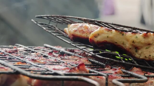Delicious cuts of marinated pork ribs and savory sausages are slowly grilling over hot coals on a rustic metal barbecue grate, producing inviting smoke and perfect char for a mouth-watering outdoor