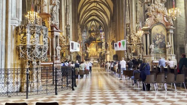 People attending a religious ceremony inside a historic cathedral in Vienna, Austria on May 4, 2026. Gothic architecture, spiritual atmosphere and ornate church interior.