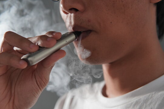 close up of a man smoking an e-cigarette
