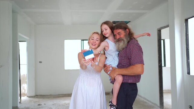 Smiling parents and daughter visiting their house construction site