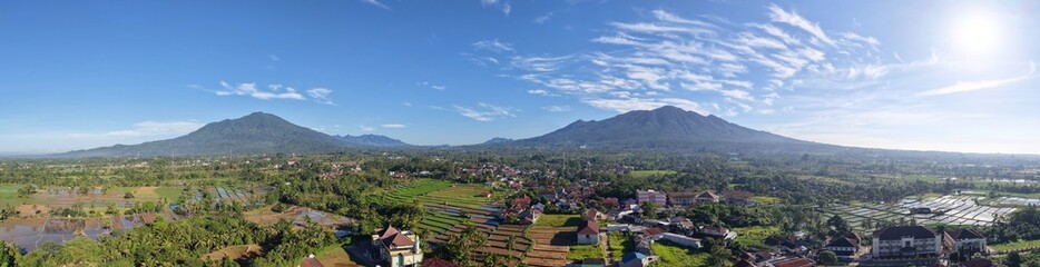Aerial Panorama of Lush Rice Fields and Volcanic Mountains © Haura