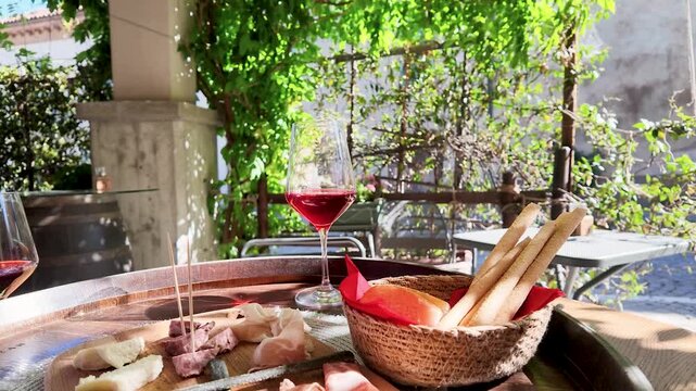 Italian Red Wine and Charcuterie Board at a Sunny Outdoor Piedmont Cafe