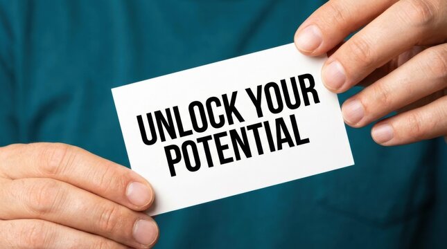 Close up of a person holding a white card with the motivational phrase unlock your potential in bold black letters promoting self