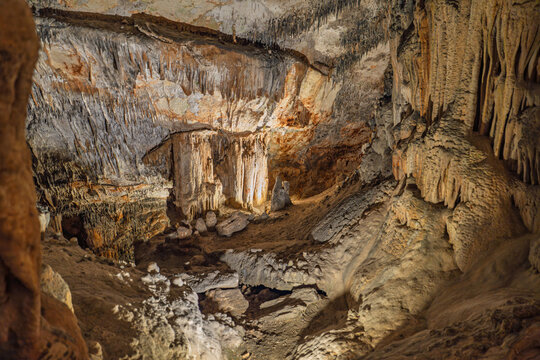 Scenic view of stalactites and stalagmites in the caves of Mallorca, Spain, where intricate underground formations create a captivating natural landscape prized by visitors.