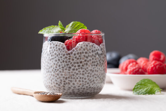 Chia pudding topped with fresh raspberries and blueberries in a glass, Healthy eating