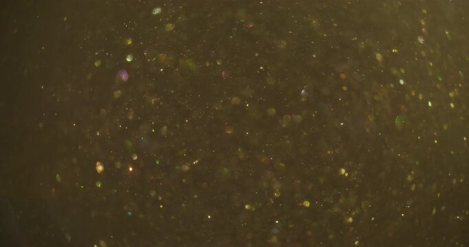 Bokeh circles. Glitter fly illumination. Yellow sparks spiral stream on dark abstract background. Color flicker dots blur texture.