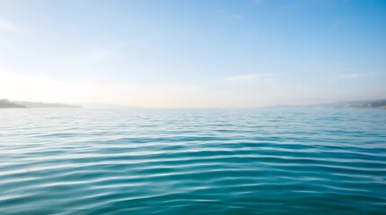 Obraz premium Calm and tranquil turquoise ocean water surface with gentle waves reflecting the bright blue sky on a clear sunny day