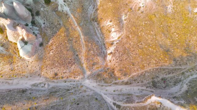 Goreme, Nevsehir, Turkey. Devrent Valley fairy chimneys and eroded tuff spires, aerial panoramic view at golden hour over the volcanic landscape. Aerial View, MasterShots, Tilt up, Zoom In