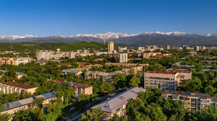 Obraz premium A view from a quadcopter of the central part of Kazakhstan's largest city, Almaty, on a sunny spring evening.