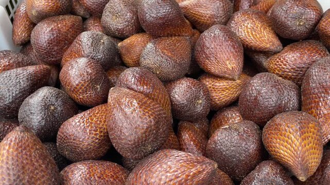 Piles of salak fruit in baskets, fresh salak fruit harvest ready for sale