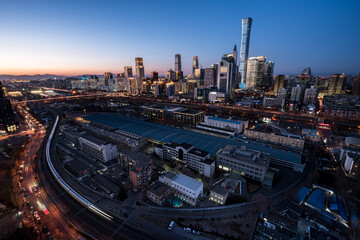 Fototapeta premium A high-angle view of Beijing's CBD skyline and urban transportation network in the blue twilight of China.
