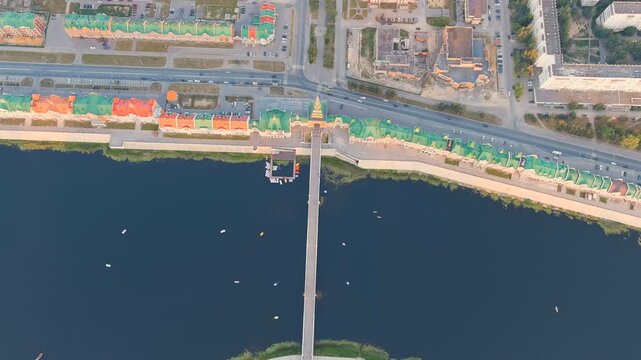 Yoshkar-Ola, Russia. Theater Bridge and Spasskaya Tower replica spanning the Malaya Kokshaga River, Drone footage over the colorful Flemish-style Bruges Embankment at sunset. Drone footage
