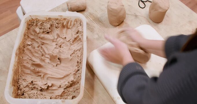 Artisan working. Handmade craft. Unrecognizable experienced woman hands molding raw for ceramic crockery in professional workspace.