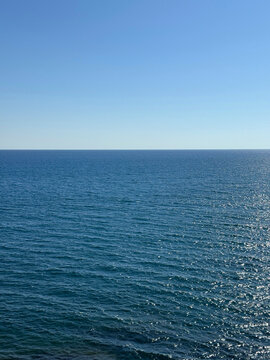 Calm blue sea and clear sky vertical.