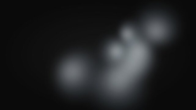 Soft white ethereal glowing light patches against a deep black background