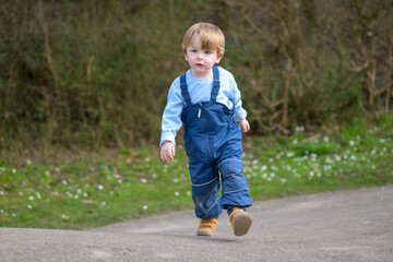 Fototapeta premium Toddler walking outdoors during spring