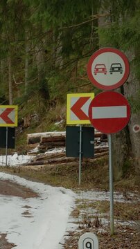 Vertical Screen: Snow covers the high-altitude mountain road, and signs indicate it is closed for winter. Drivers must turn back as they face restrictions due to weather conditions.