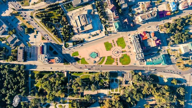 Lipetsk, Russia. Peter the Great Square, aerial top-down view over the geometric plaza, busy highway, and surrounding city blocks under bright summer sun. Drone footage, HEAD OVER SHOT