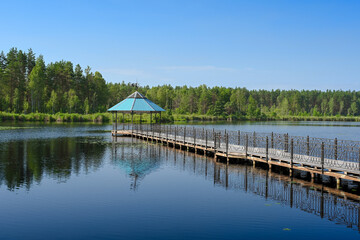 Fototapeta premium Gazebo on the water in the middle of Central Lake in Orlovskoye Polesie National Park, Oryol region of Russia