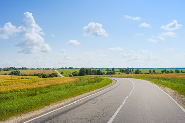 Fototapeta premium Empty winding highway through the endless fields and hills of the Oryol region, Oryol region of Russia
