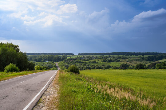 Picturesque empty highway through fields to forests on the horizon, Oryol region of Russia