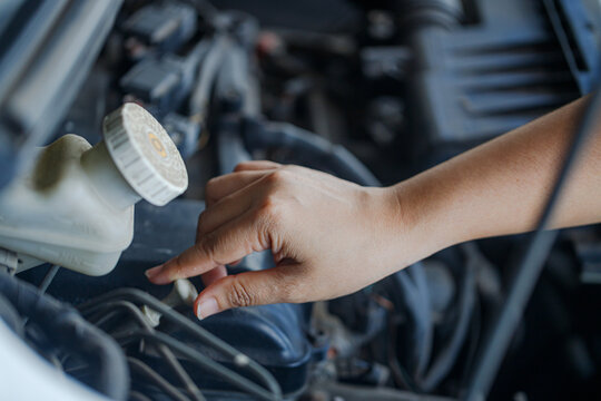 Close up of a hand of woman is checking a liquid coolant pot
