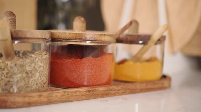 Spice jars on wooden tray in bright kitchen setting