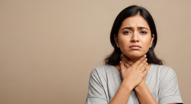 Woman touching her neck because of sore throat. Young lady feeling pain or discomfort in throat area. Health problem and medical symptom concept for pharmacy and healthcare website.