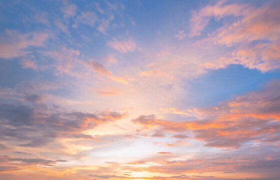 Soft pastel clouds glow with sunset's warmth
