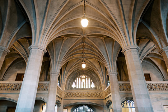 Ancient arches illuminated. Grand vaulted ceilings with intricate carvings. Majestic stone arches bathed in warm clerestory illumination