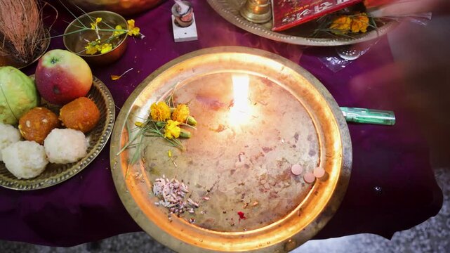 devotee hand worshiping aarti after traditional pooja offerings at indoors on festive occasion