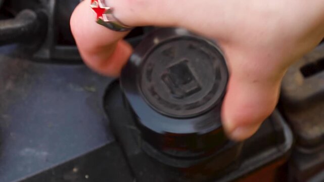 Video twisting the gas cap of a mower.