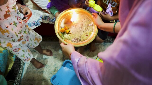 people taking holy aarti at home after god worship