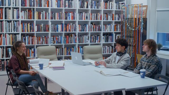 Group of young college students brainstorming and collaborating on a project in a school library