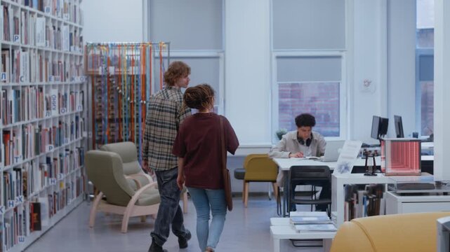 Young diverse students collaborating on a group assignment using a laptop in a university library