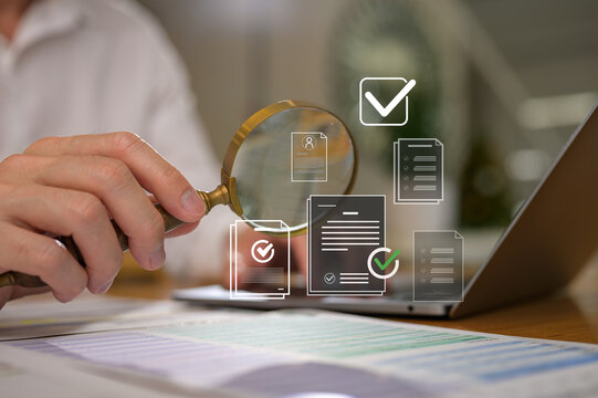 businessman holding magnifying glass looking at virtual data chart dashboard in concept of investment data analysis and DMS document audit financial Tax Fraud audit Using Magnifying Glass