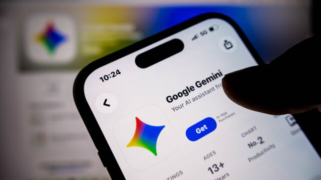 Closeup of a persons hand holding a smartphone displaying the google gemini app page on the apple app store