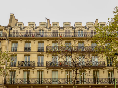 Ornate haussmann building facade in Paris, France. Classic architecture with wrought iron balconies and dormer windows