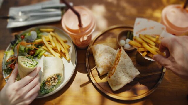 People enjoying lunch together with burritos and french fries