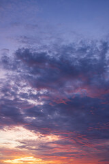Fototapeta premium Dramatic Sunset Sky with Vibrant Twilight Clouds,Beautiful twilight sky during sunset featuring a dramatic blend of deep blue and purple clouds illuminated with vibrant orange, pink, and yellow hues.