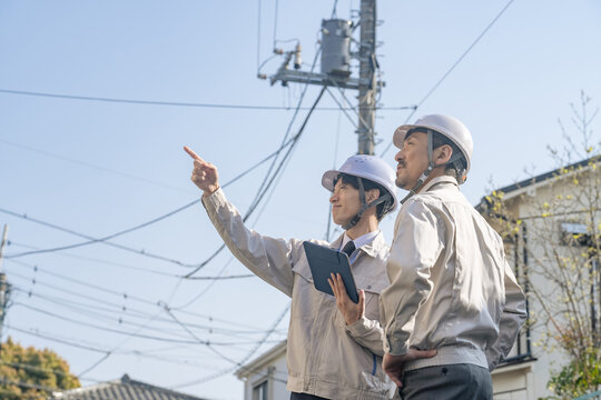 住宅地に立つ男性作業員のグループ