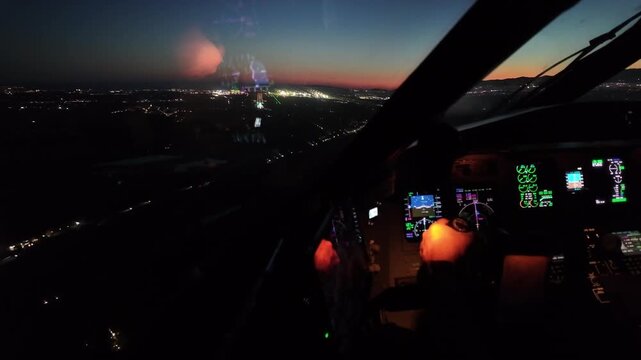 Pilot&rsquo;s eye view in a night approach to Malaga Airport (AGP) at twilight, with the hand of the pilot flying illuminated, and the runway 31 ahead.