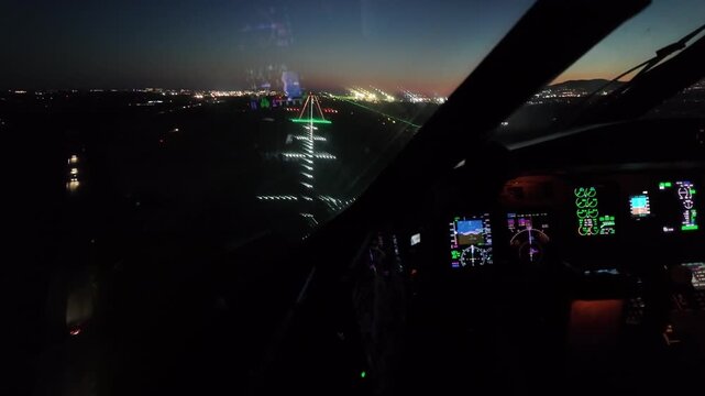 immersive cockpit window view captured at twilight of the final approach to Malaga (AGP) airport runway 31, with a view of the hand of the pilot on the controls and the flight instruments.