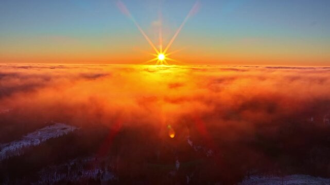 Vibrant sunrise light bursting across foggy horizon surreal atmosphere