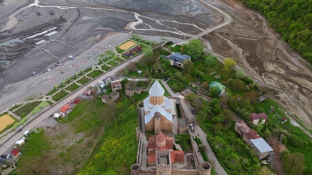 Aerial view of Ananuri Fortress Complex and the Church of the Mother of God overlooking the Aragvi River in Georgia. Historical medieval architecture in a lush mountain landscape