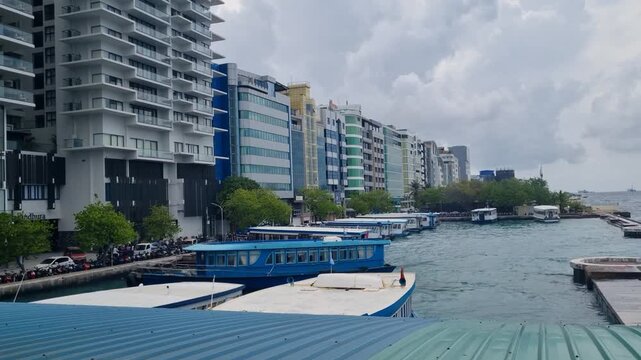 Coastal promenade and harbor of Mal&eacute;, Maldives, serving as a main entry point for tourists arriving to the island paradise, shown on an overcast day with calm urban waterfront atmosphere