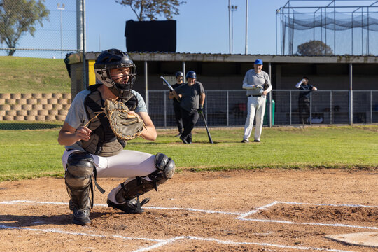 Baseball catcher crouching at home plate receiving incoming pitch, animated pitch arc marking mitt